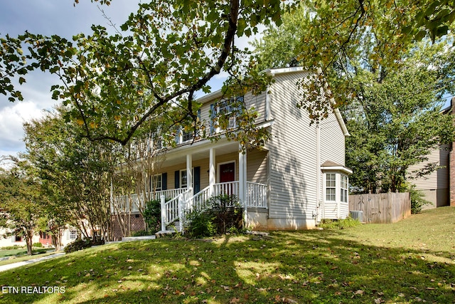 view of front facade featuring central AC unit, a front lawn, and covered porch