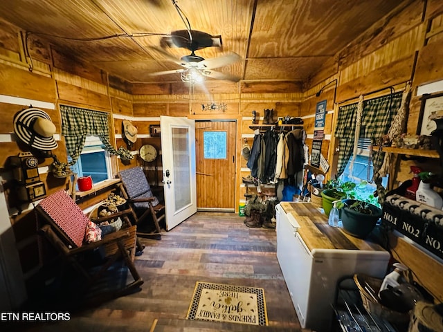 misc room with dark hardwood / wood-style floors, wooden walls, ceiling fan, wooden ceiling, and french doors