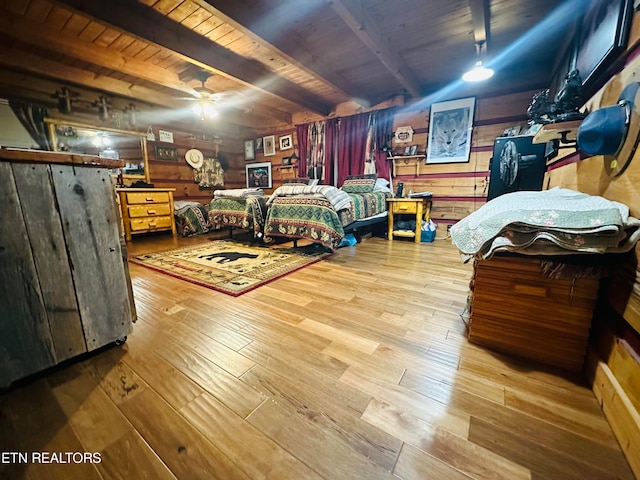 bedroom with wood ceiling, light hardwood / wood-style floors, wooden walls, and beamed ceiling