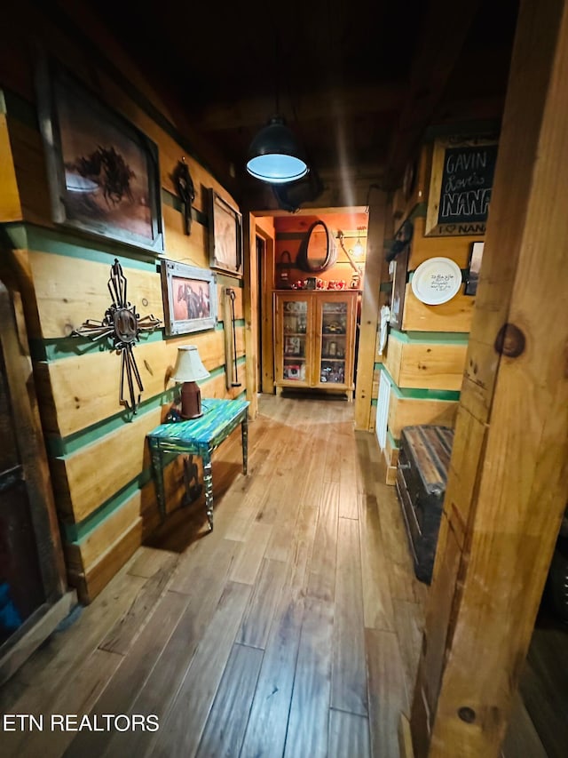 hallway featuring wood walls and hardwood / wood-style floors