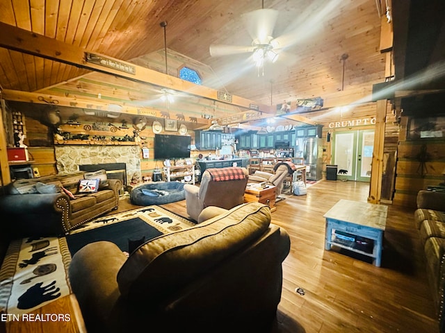 living room with wood ceiling, lofted ceiling, ceiling fan, hardwood / wood-style flooring, and wooden walls