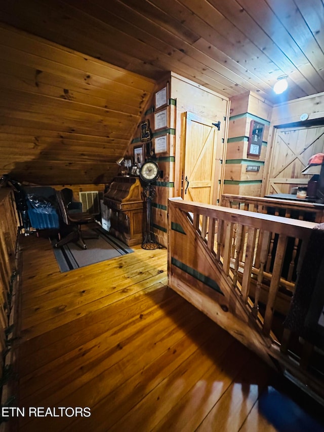 additional living space featuring wood ceiling, vaulted ceiling, wood walls, and hardwood / wood-style flooring