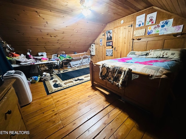 bedroom featuring lofted ceiling, wood walls, hardwood / wood-style floors, and wooden ceiling