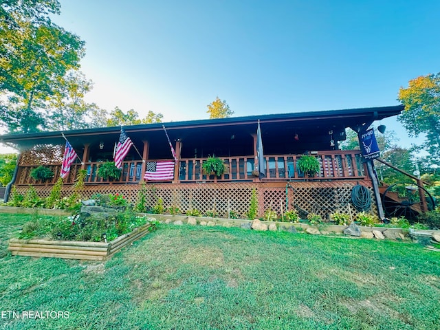 rear view of property featuring a yard and a wooden deck