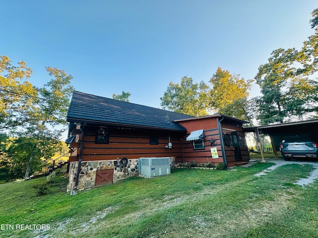 back of property with a lawn and a carport