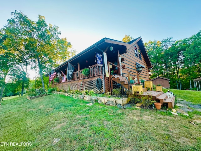 back of property with a deck and a yard