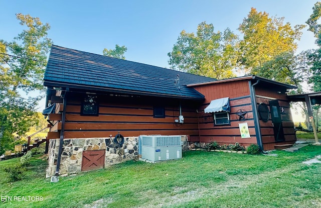 view of side of home featuring a lawn and central air condition unit