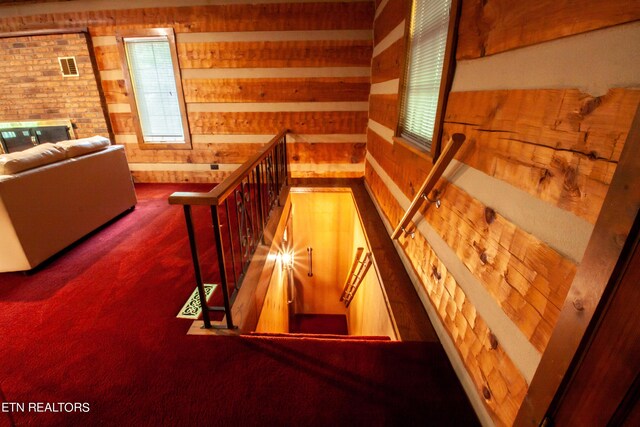 stairs featuring wooden walls and carpet flooring