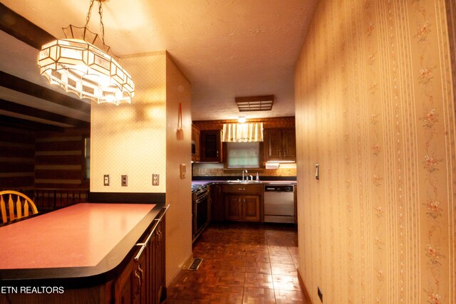 kitchen with kitchen peninsula, dishwasher, a textured ceiling, wall oven, and sink