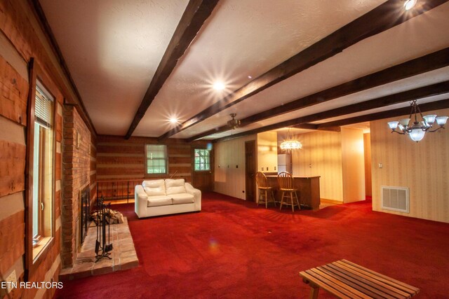 interior space with a fireplace, beam ceiling, a chandelier, and carpet flooring