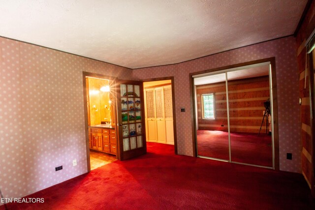 unfurnished bedroom featuring a textured ceiling and carpet flooring