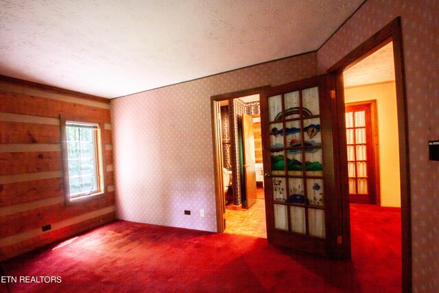 carpeted empty room with a textured ceiling and crown molding