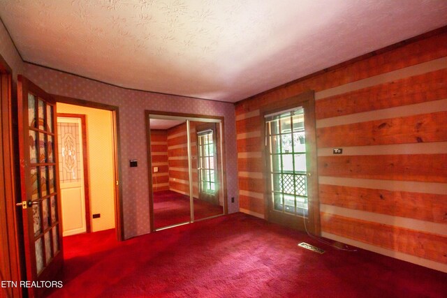 unfurnished bedroom with a textured ceiling, carpet flooring, and a closet