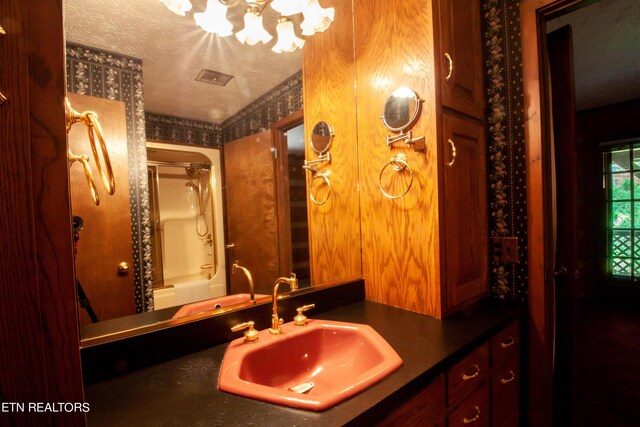 bathroom with vanity, a textured ceiling, and bathtub / shower combination