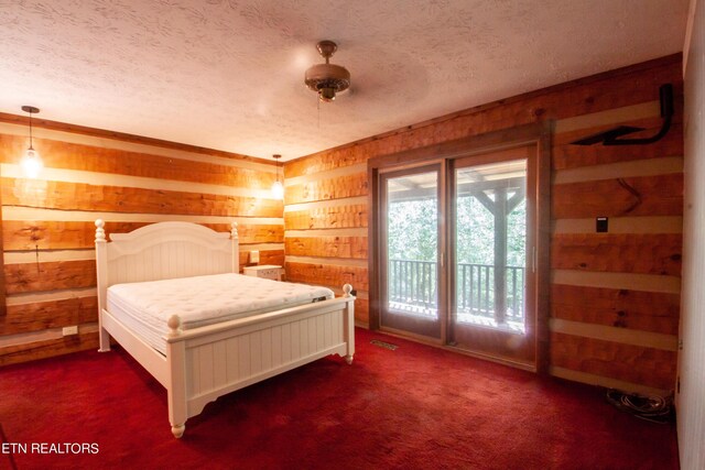 carpeted bedroom featuring a textured ceiling, wooden walls, and access to exterior