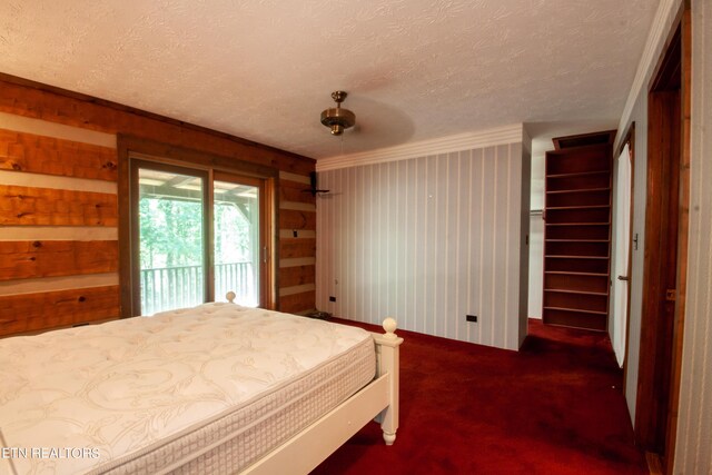 carpeted bedroom featuring a textured ceiling, crown molding, ceiling fan, access to outside, and wooden walls