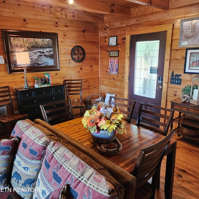 dining room featuring wood walls and hardwood / wood-style floors