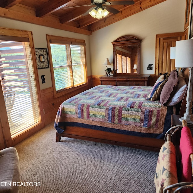 carpeted bedroom with ceiling fan, beamed ceiling, wood walls, and wooden ceiling