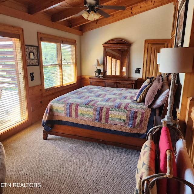 bedroom with wood walls, beam ceiling, multiple windows, and wooden ceiling