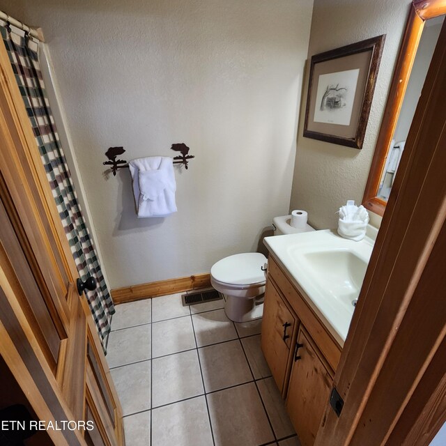 bathroom with tile patterned flooring, vanity, toilet, and a shower with curtain