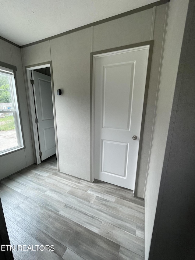 unfurnished bedroom with light hardwood / wood-style flooring and a closet