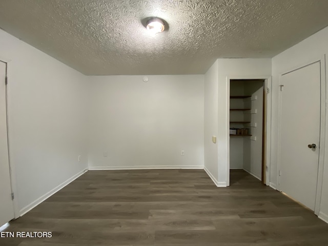 bonus room with dark hardwood / wood-style floors and a textured ceiling