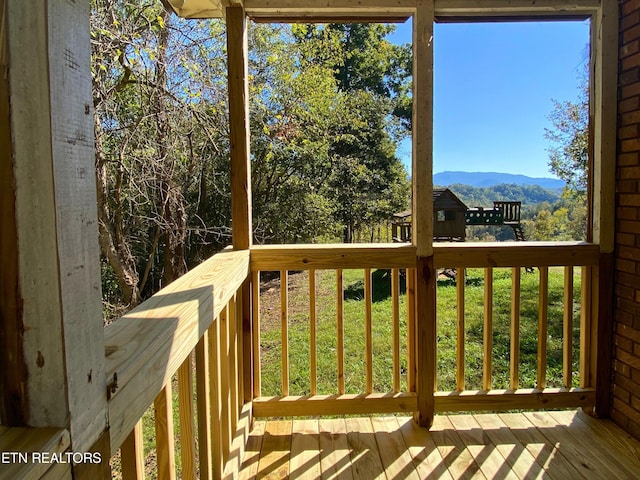 deck featuring a mountain view and a lawn