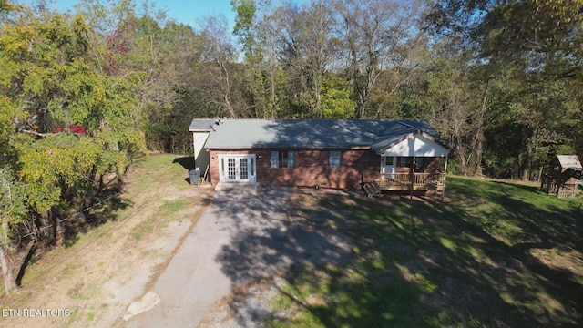 view of front facade with a deck and a front lawn