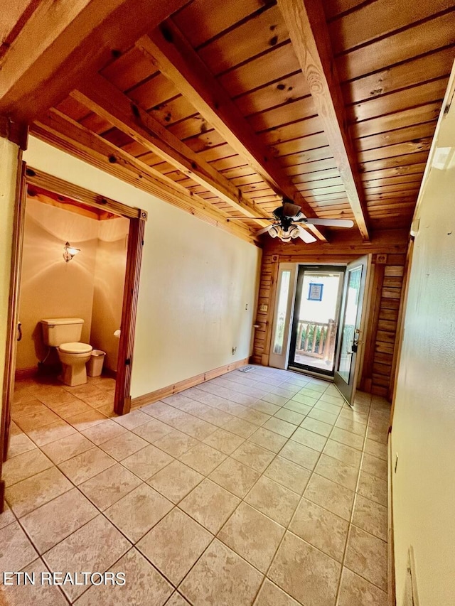 empty room with wood ceiling, beam ceiling, ceiling fan, and light tile patterned flooring
