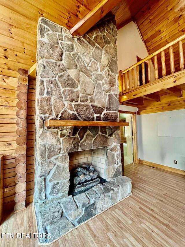 room details with baseboards, wood finished floors, wood ceiling, and a stone fireplace