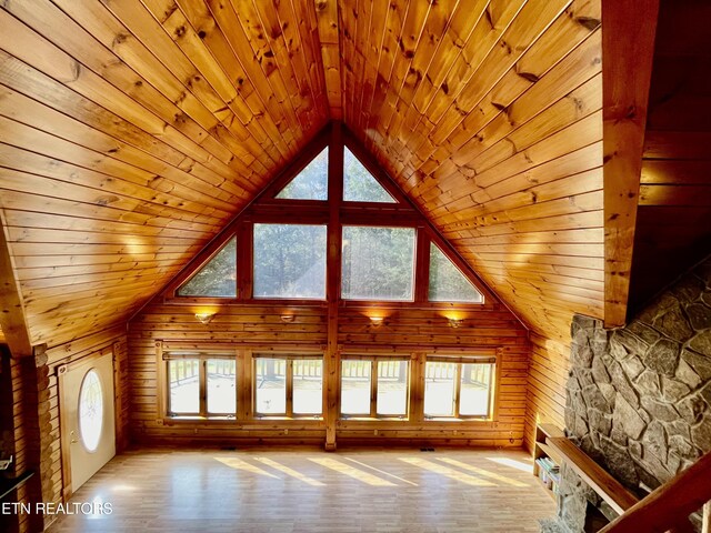 interior space with wooden ceiling, a healthy amount of sunlight, wood walls, and hardwood / wood-style floors