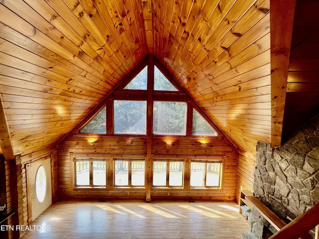 additional living space with plenty of natural light, wooden ceiling, and wooden walls