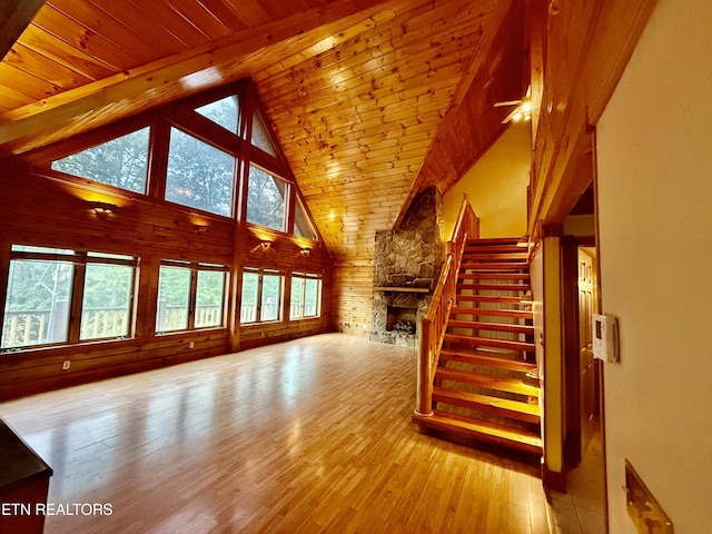 living area featuring wooden ceiling, stairs, hardwood / wood-style floors, and wooden walls