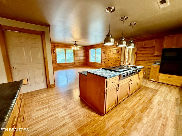 kitchen with wooden walls, ceiling fan, and light hardwood / wood-style flooring