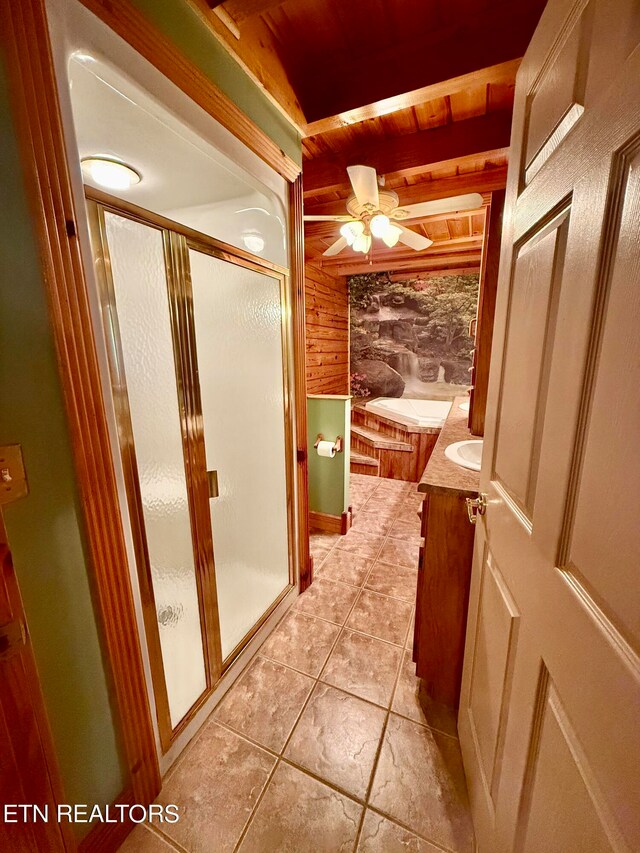 bathroom with ceiling fan, vanity, wood walls, walk in shower, and tile patterned flooring