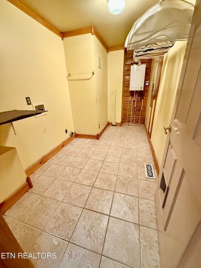 hall featuring crown molding and light tile patterned floors