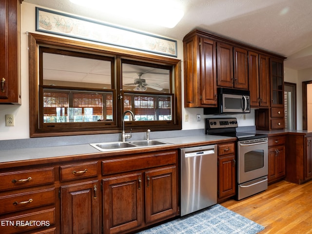 kitchen with ceiling fan, sink, a textured ceiling, light hardwood / wood-style flooring, and stainless steel appliances