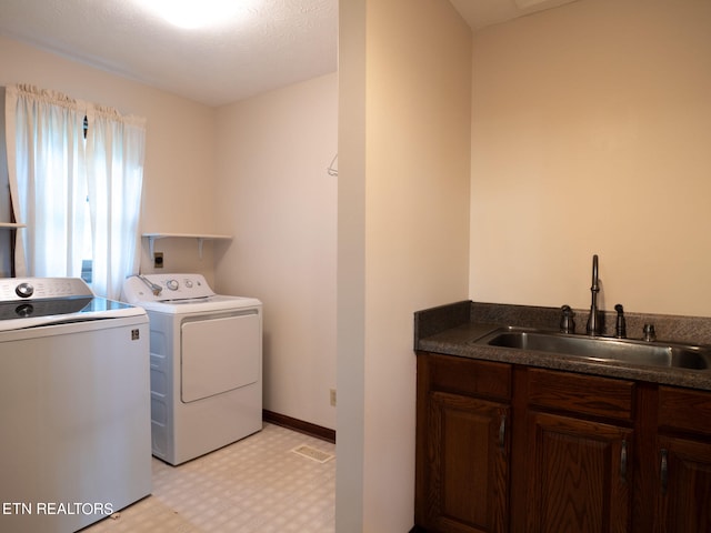 laundry room with a textured ceiling, sink, and independent washer and dryer