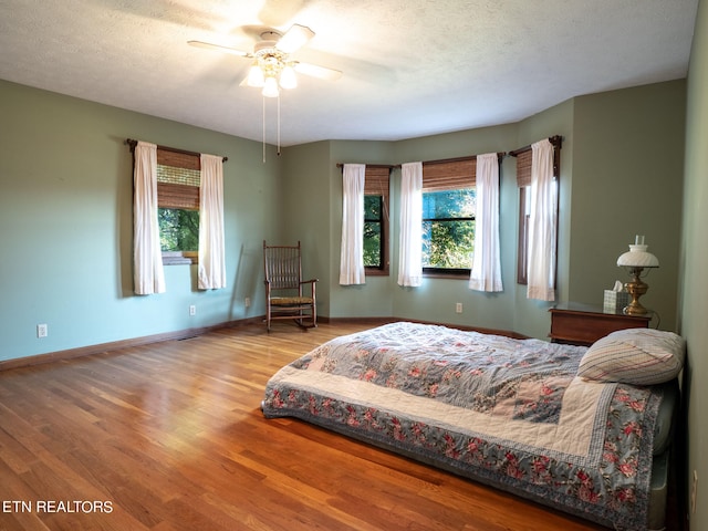 bedroom featuring a textured ceiling, ceiling fan, and hardwood / wood-style flooring