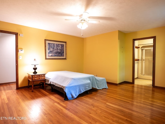 bedroom with wood-type flooring, ceiling fan, and a textured ceiling