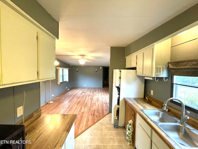 kitchen with white refrigerator, sink, and ceiling fan