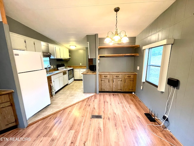 kitchen featuring lofted ceiling, a chandelier, hanging light fixtures, light hardwood / wood-style flooring, and white appliances