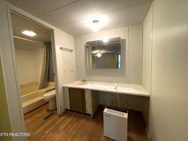 full bathroom with shower / bathtub combination with curtain, vanity, hardwood / wood-style flooring, and toilet