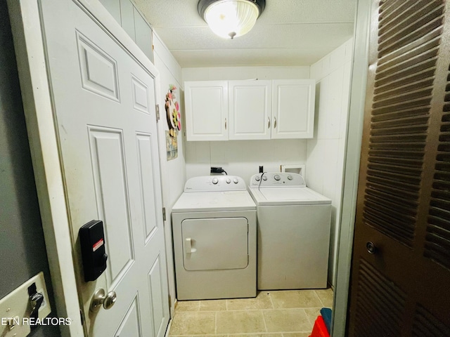 washroom featuring cabinets and washer and clothes dryer