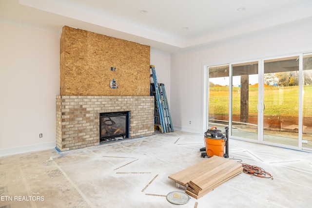 living room with a tray ceiling and a fireplace