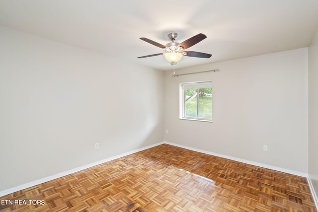 empty room featuring ceiling fan and parquet flooring