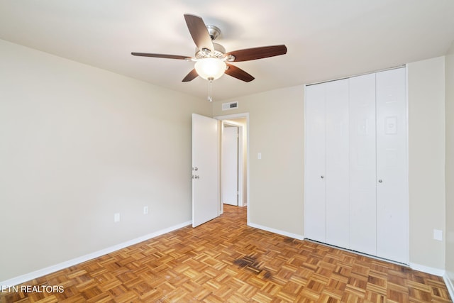 unfurnished bedroom featuring light parquet flooring and ceiling fan