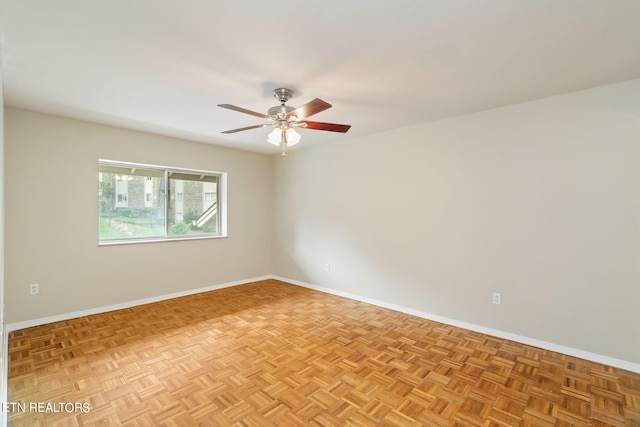 empty room with ceiling fan and light parquet floors