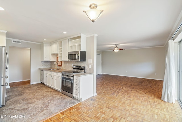 kitchen with white cabinets, stainless steel appliances, sink, and light parquet flooring