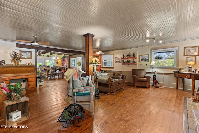 living room with decorative columns, ceiling fan, and wood-type flooring